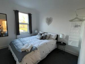 a bedroom with a large bed with pillows and a window at Hill Grove 2 Bedroom Apartment in Leigh-on-Sea