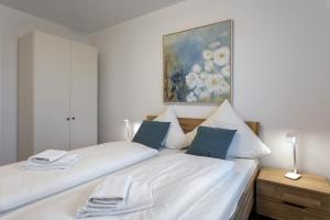 a bedroom with two beds and a painting on the wall at Ferienwohnung eastside App 3 Olpenitz in Olpenitz +27 photos