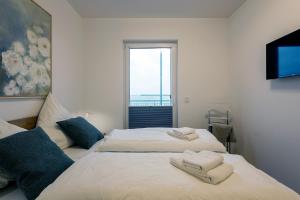 two beds in a room with a window at Ferienwohnung eastside App 3 Olpenitz in Olpenitz
