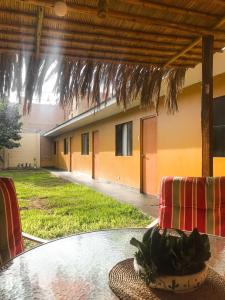 une table extérieure avec des chaises et un bâtiment dans l'établissement Casa - Hospedaje Munay Ki - Yoga -, à Pisco