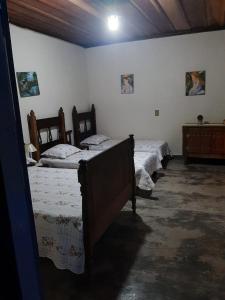 Un grupo de 4 camas en una habitación en Casa Cabocla da Mantiqueira, en Bueno Brandão