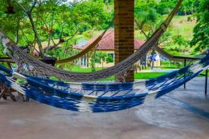 a blue and white hammock in front of a house at Casas da Mantiqueira in Bueno Brandão
