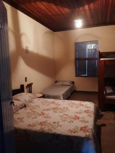 1 dormitorio con 2 camas y ventana. en Casa Cabocla da Mantiqueira, en Bueno Brandão