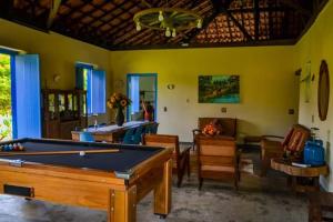 a living room with a pool table and chairs at Casas da Mantiqueira in Bueno Brandão