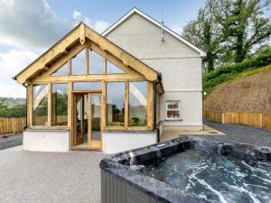 a house with a hot tub in front of it at 4 Bed in New Quay 78801 in Llandyssiliogogo
