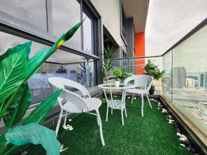 d'une terrasse avec des chaises blanches et une table sur un balcon. dans l'établissement Loft Suite CityView near JB CIQ 7Pax, à Johor Bahru