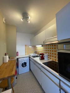 a kitchen with a washing machine and a washer at Cosy & Spacious with Eiffel Tower view in Puteaux