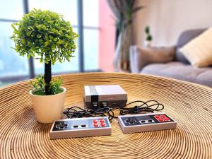 a table with two remote controls and a plant on it at Loft Suite CityView near JB CIQ 7Pax in Johor Bahru