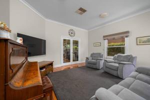 a living room with a flat screen tv and a couch at Stay at beautiful Rea in Shepparton