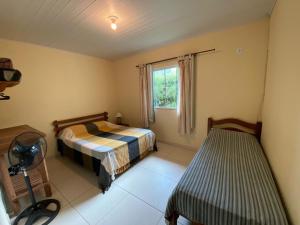 1 dormitorio con 2 camas y ventana en Lumiar casa solar churrasqueira com 3 quartos sendo um suíte arejada, jardim a 700m do centro, en Lumiar
