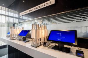 Un mostrador con dos monitores de computadora encima. en Radisson Blu Hotel, Hamburg, en Hamburgo 180 fotos más