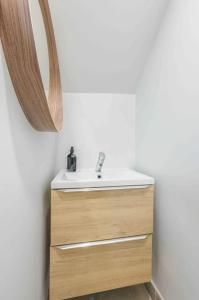 a bathroom with a sink and a mirror at Le Petit Tremblay at 10 min Parc des Expos / CDG in Tremblay En France