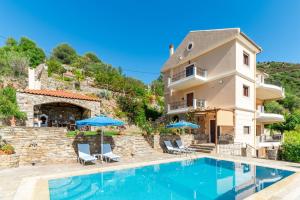 a villa with a swimming pool and a house at Villa Lumière- Avantes in Agioi Apostoli