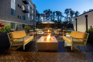 a patio with tables and chairs and a fire pit at WaterWalk Huntsville in Huntsville