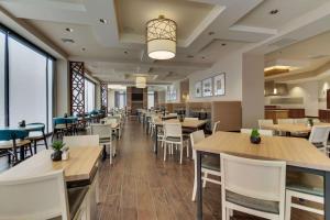 une salle à manger avec des tables et des chaises blanches dans l'établissement Drury Plaza Hotel Nashville Downtown, à Nashville