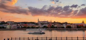 a boat on the river in a city at sunset at DN Green apartment in Budapest