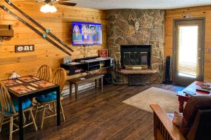 a living room with a table and a television in a room at Silver Creek - Door 418 in Granby