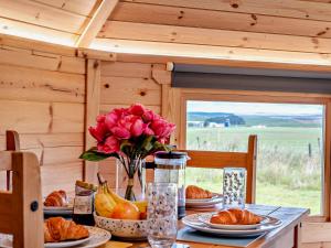 een tafel met eten en een vaas met bloemen en fruit bij 1 Bed in Biggar 91248 in Libberton