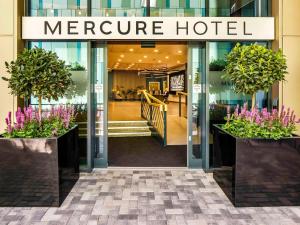 Mercure Newport في نيوبورت: متجر أمام فندق مدمج مع زهور أرجوانية