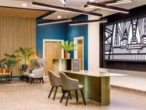 a lobby with chairs and a table and a tv at Mercure Newport in Newport