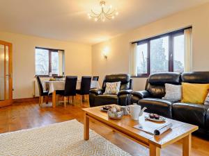 a living room with leather furniture and a table at 3 Bed in Kington 90768 in Kinnerton