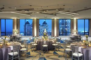 a ballroom with tables and chairs and large windows at The Starling Atlanta Midtown, Curio Collection by Hilton in Atlanta