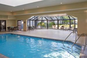 a pool in a hotel with tables and chairs at Sonesta Select Minneapolis Eden Prairie in Eden Prairie