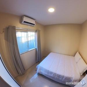 a bedroom with a bed and a window at Recanto dos Amigos in Santo Amaro