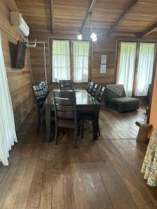 een eetkamer met een tafel en stoelen en een bank bij Cabaña eluney in Ocean Park