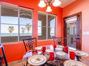 a dining room with orange walls and a table and chairs at Beachfront San Felipe Villa 721 in San Felipe