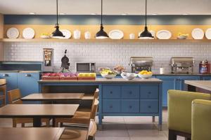 una cocina con armarios azules, mesas y platos en Country Inn & Suites by Radisson, Abingdon, VA, en Abingdon