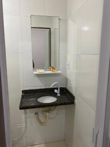 y baño con lavabo y espejo. en Lindo Flat pé na areia en Salvador
