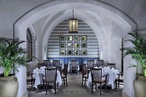 a restaurant with white tables and chairs and a chandelier at Steigenberger Alcazar in Sharm El Sheikh