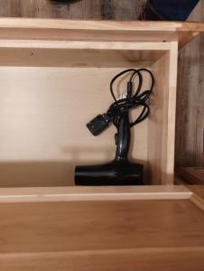 a black remote control in a wooden drawer at Beargrass Lodging & RV Resort in Hungry Horse