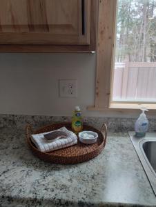 una encimera de cocina con una cesta con toallas y un fregadero en Beargrass Lodging & RV Resort, en Hungry Horse