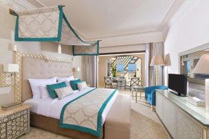 a bedroom with a king sized bed and a balcony at Steigenberger Alcazar in Sharm El Sheikh