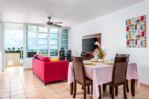 a dining room with a table and a red couch at Tropical Villa Ocean View in Maunabo