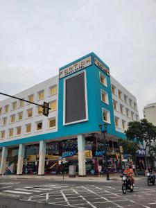 um grande edifício numa rua com pessoas a andar de mota em FORTICH APART HOTEL em Guayaquil
