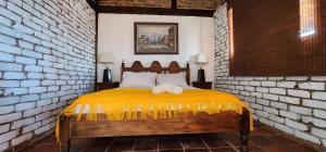 a bedroom with a bed in a brick wall at Mitanni in Santa Isabel