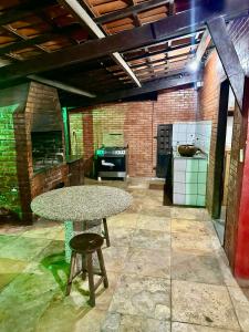 a large kitchen with a table and a stove at Casa de Praia - Prainha in Aquiraz