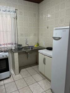 eine Küche mit einem weißen Kühlschrank und einer Spüle in der Unterkunft Casa na Vila Yolanda in Foz do Iguaçu