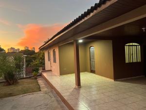 ein Haus mit einer Terrasse mit Blick auf den Sonnenuntergang im Hintergrund in der Unterkunft Casa na Vila Yolanda in Foz do Iguaçu