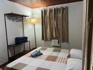 ein Schlafzimmer mit einem Bett mit einem Koffer drauf in der Unterkunft Casa na Vila Yolanda in Foz do Iguaçu