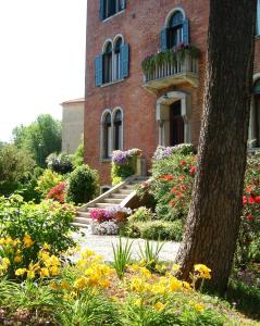 un edificio de ladrillo con flores delante en B&B Villa Ines, en Lido de Venecia