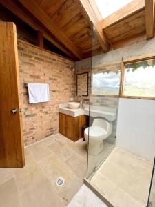 La salle de bains est pourvue de toilettes et d'une douche en verre. dans l'établissement Gran CASA FINCA embalse de Tominé wi-fi, tv, BBQ, à Sesquilé