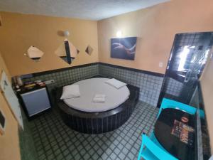 a small bathroom with a tub with a toilet at Eclipse Motel in Recife