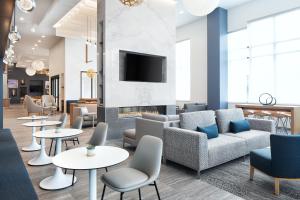 Element Minneapolis Downtown North Loop في مينيابوليس: لوبى به أريكة وطاولات ومدفأة