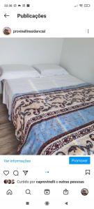 a bedroom with a bed with a blanket on it at Pousada Provinelli in Palhoça
