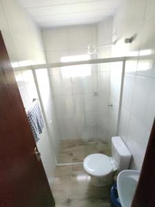 een kleine badkamer met een toilet en een wastafel bij Pousada Provinelli in Palhoça