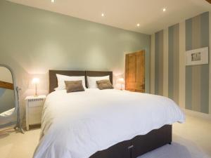 a bedroom with a large white bed with striped walls at 3 Bed in Keswick SZ030 in Keswick